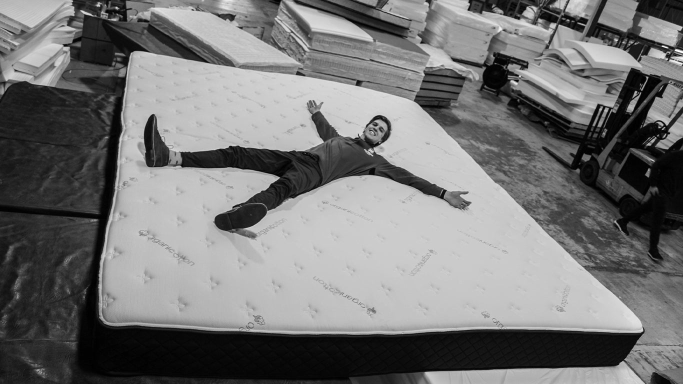 a man laying on an oversized, custom engineered sleep mattress