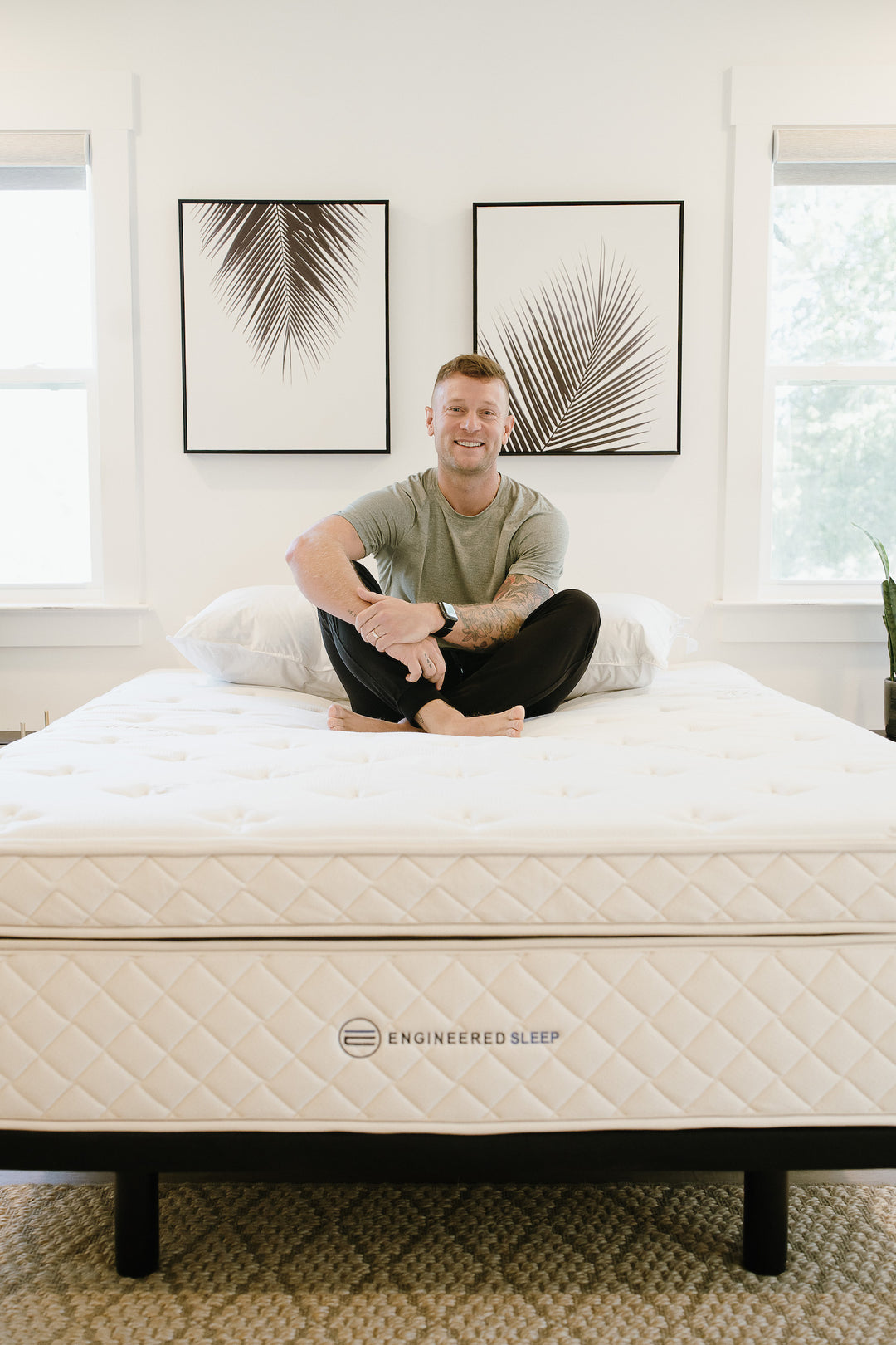 a man smiling sitting on our DUO hybrid latex mattress