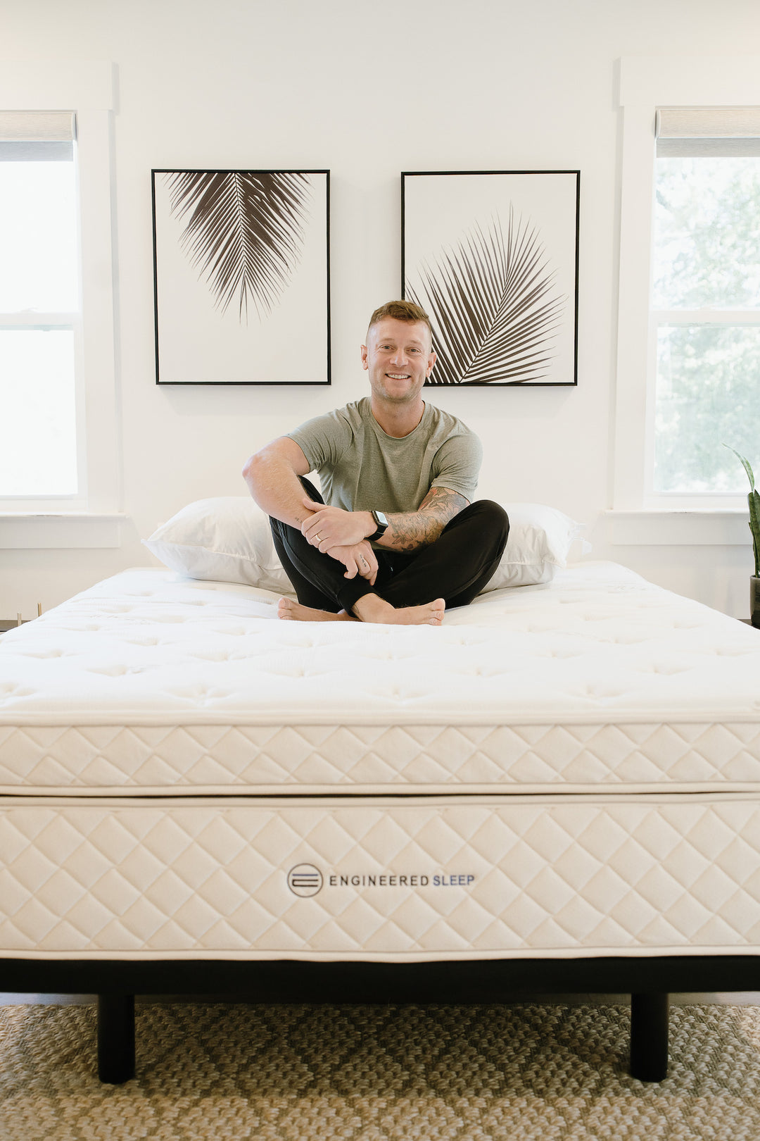 a man smiling sitting on a hybrid latex mattress