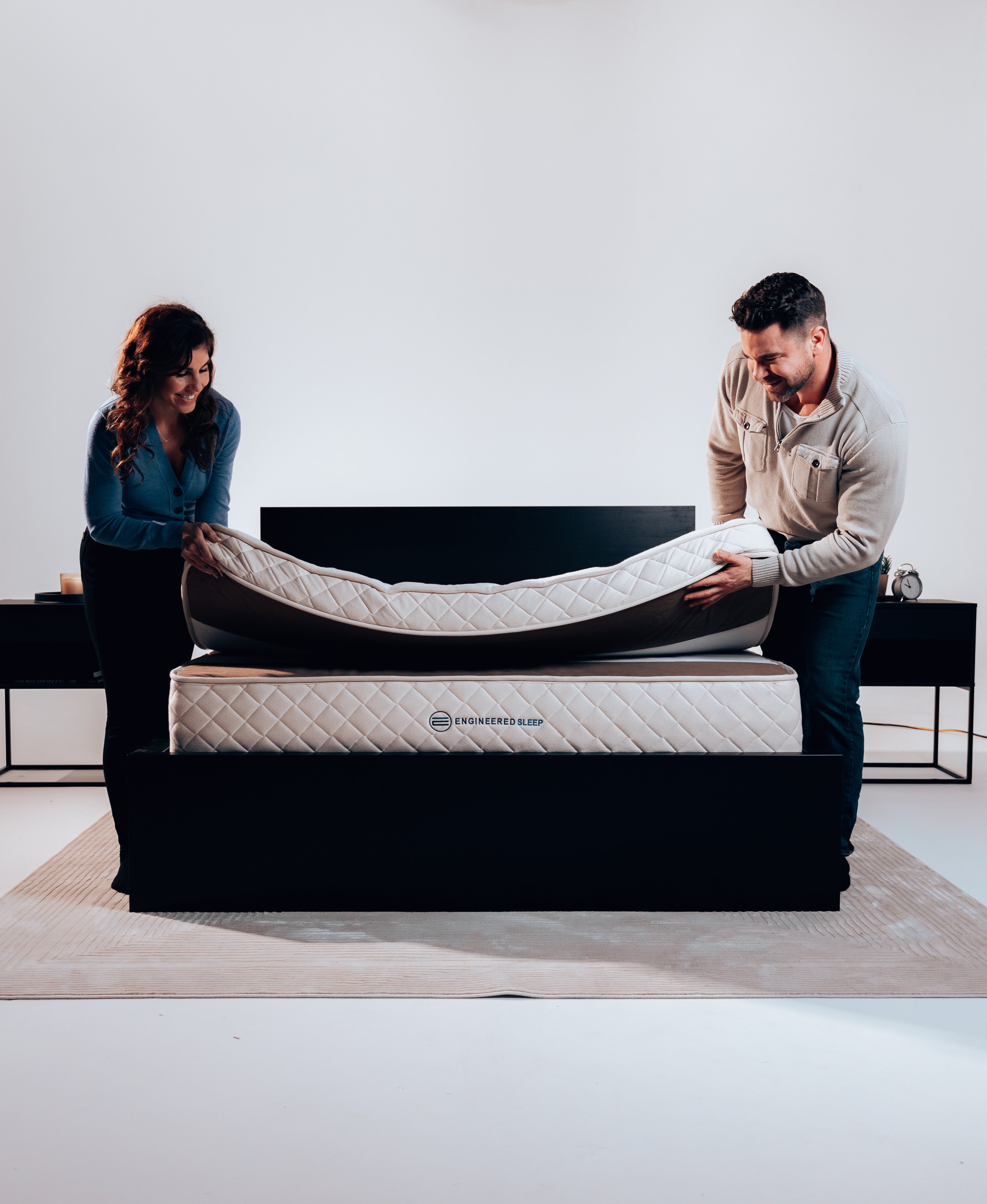 A couple showcasing the 2-piece design of a DUO Latex hybrid mattress