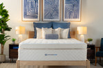 Mattress on a bed in a bedroom with decorative pillows and lamps.